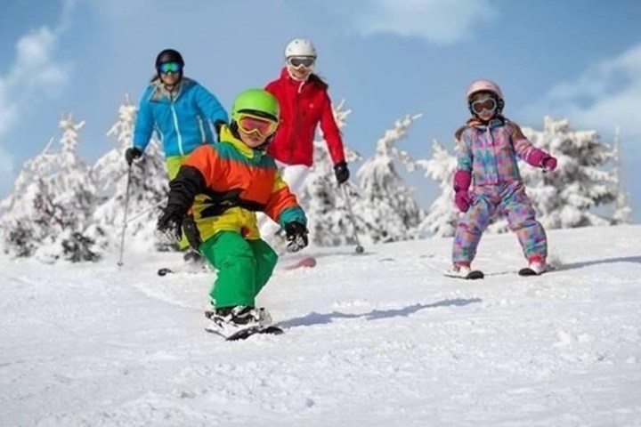 a person riding a snowboard down a snow covered slope